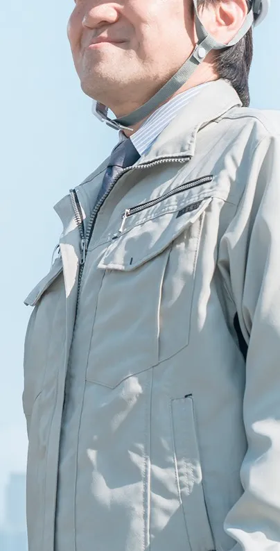 清潔感のある作業服に身を包み、スッキリとした笑顔を浮かべる現場スタッフの姿。