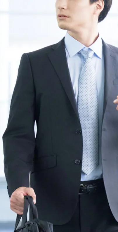 ビジネスバッグを手に、前を向いて颯爽と歩くスーツ姿の男性。