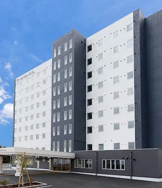 WORKERS HOTEL熊本大津店の建物全景。モノトーンで統一されたスタイリッシュな佇まい。