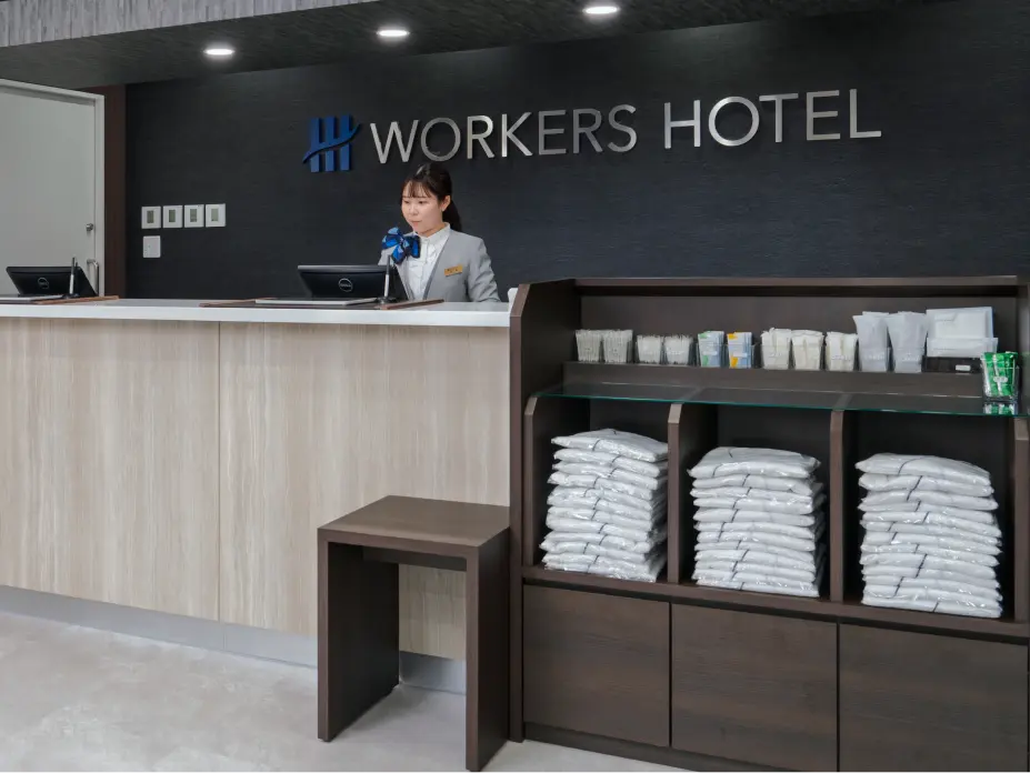 ワークスホテル(WORKERS HOTEL)のフロントカウンターと奥のアメニティ棚