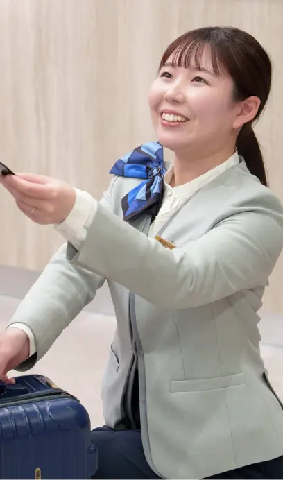 荷物を預かる笑顔のフロントスタッフ